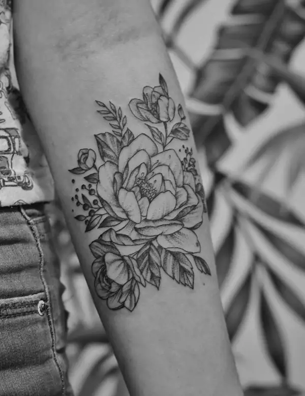 A fine-line peony on a forearm, in black and grey